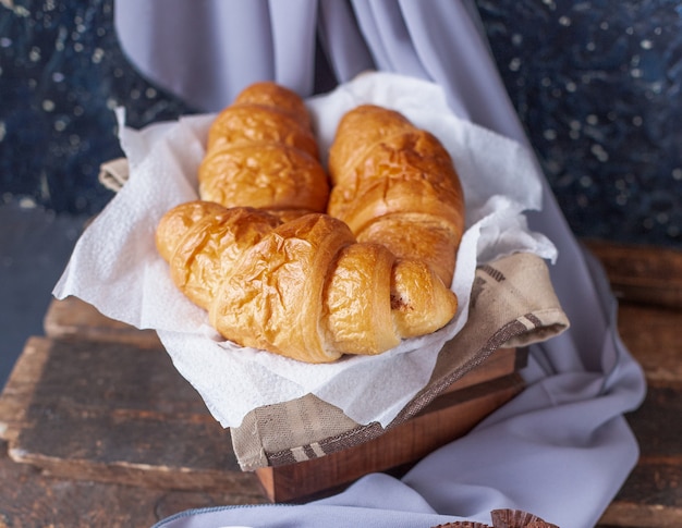 Croissants inside a wooden box on a piece of white tissue Free Photo