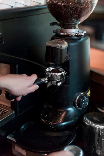 Crop hands grinding coffee into portafilter Free Photo Crop hands grinding coffee into portafilter Free Photo