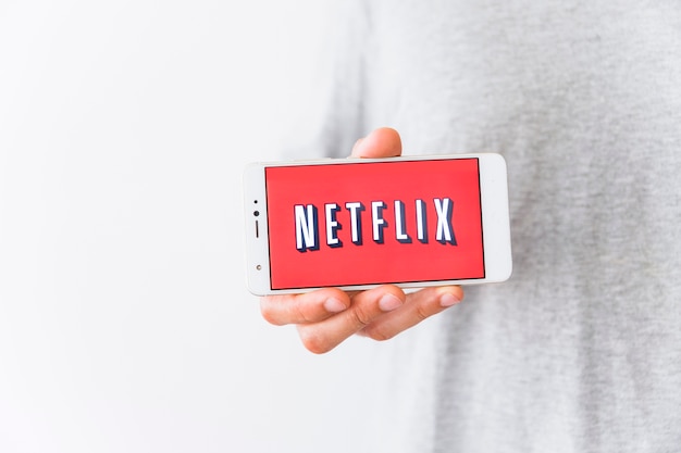 Download Free Crop Man Showing Smartphone With Netflix Logo Free Photo Use our free logo maker to create a logo and build your brand. Put your logo on business cards, promotional products, or your website for brand visibility.