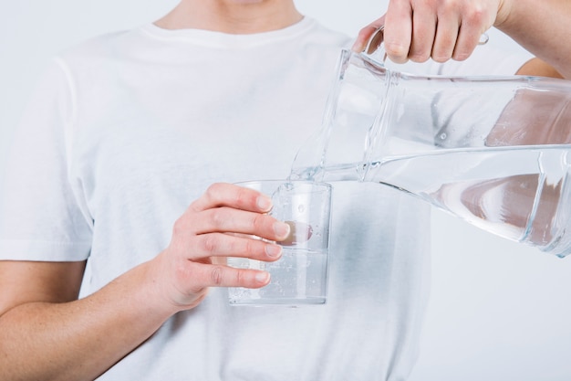 Crop woman filling glass with water Free Photo