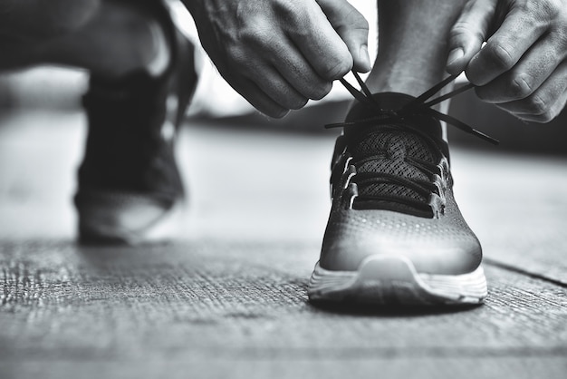 Premium Photo | Cropped image of hands tying shoelaces on sneaker ...