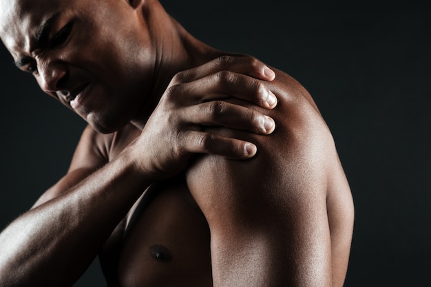 Cropped photo of young shirtless afro american man with shoulder pain Free Photo