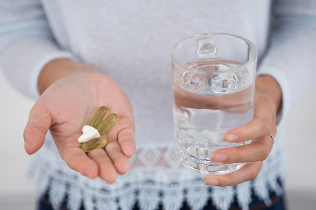 Cropped view of girl with pills and glass of water Free Photo