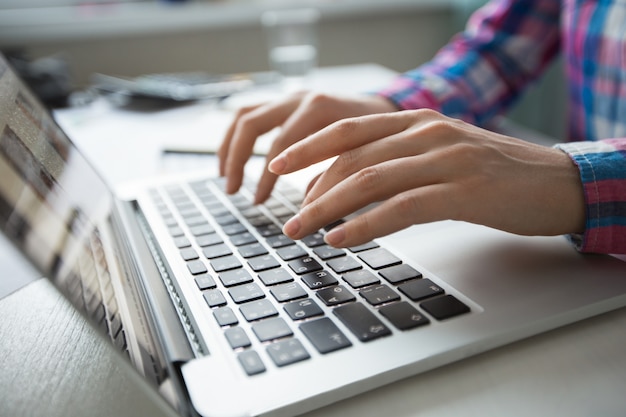 Cropped view of hands typing on laptop Free Photo