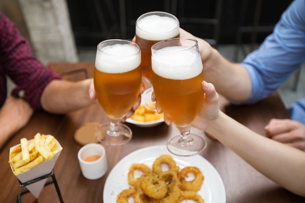 Cropped View of Friends Clinking Glasses of Beer Free Photo