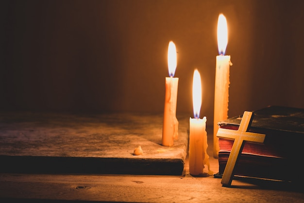 Premium Photo | Cross with bible and candle on a old oak wooden table ...