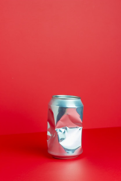 Download Premium Photo Crumpled Aluminum Can On A Red Table Without Plastic Environmental Pollution Minimalism Design PSD Mockup Templates