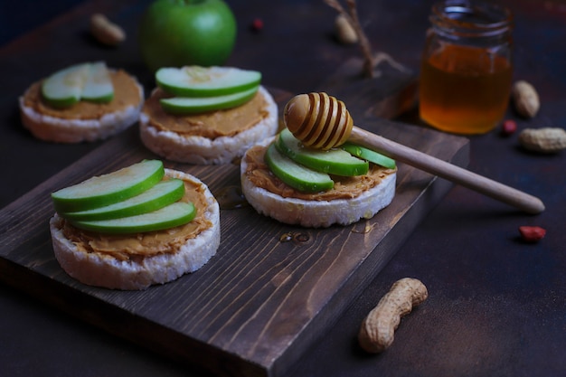 Free Photo Crunchy Natural Peanut Butter Sandwich With Rice Cake Bread And Green Apple Slices And Honey