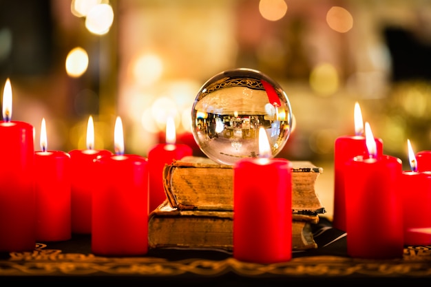 Crystal ball in the candle light to prophesy Premium Photo