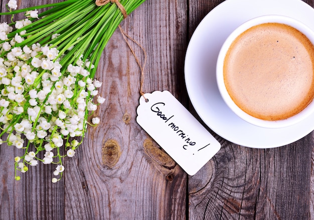 Premium Photo | Cup of cappuccino and a bouquet of white lilies of the ...