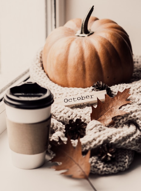 Premium Photo | Cup of coffee, pumpkin, dried autumn leaves on window.
