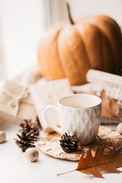 Premium Photo | Cup of coffee, pumpkin, dried autumn leaves on window.