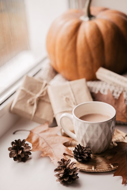 Premium Photo | Cup of coffee, pumpkin, dried autumn leaves on window.