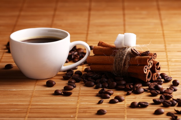 Cup of hot coffee and cinnamon sticks Free Photo