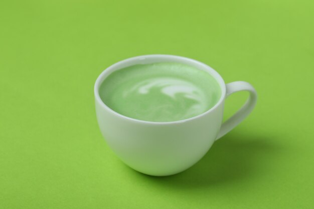 Premium Photo | Cup of matcha latte on green background