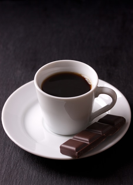 Cup of black coffee with a piece of chocolate Photo | Free Download