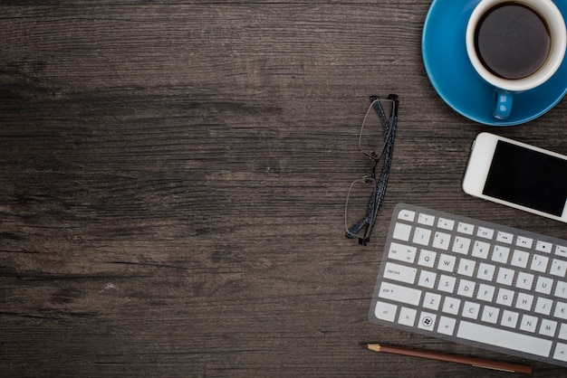 Cup of coffee on a desk with a laptop and some glasses to see Free Photo