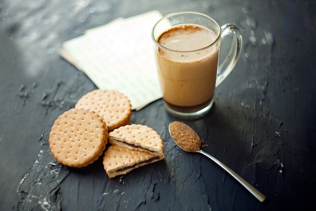 クッキーと茶色のシュガーが入った一杯のコーヒー淹れたてのラテとチョコレートを添えて プレミアム写真