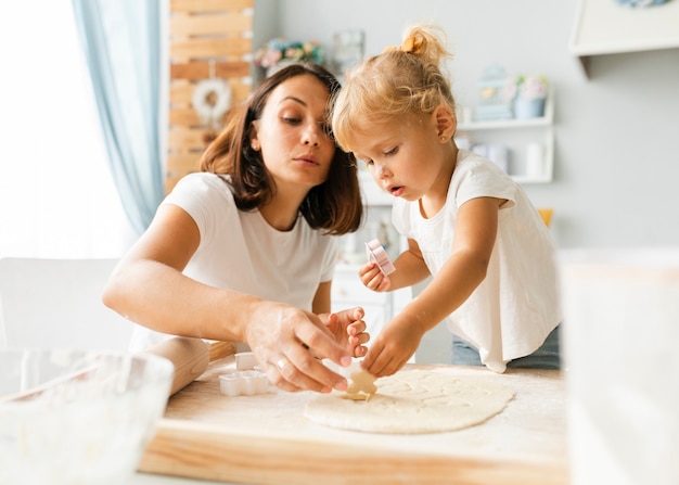 Free Photo | Curious little daughter and mother preparing cookies