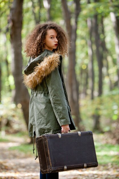 Curly Hair Teen Girl With Retro Suitcase In Autumn Forest