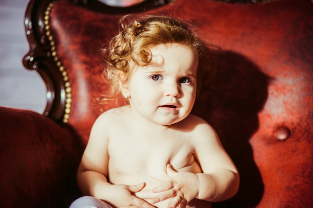 Curly Haired Blonde Toddler Sitting In Chair Photo Free Download