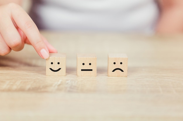 Premium Photo | Customer pressing smiley face emoticon on wood cube