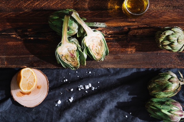 Cut artichoke between oil and lemon Free Photo