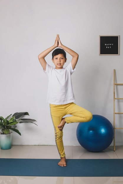 Premium Photo | Cute asian child in tree pose vrikshasana at home