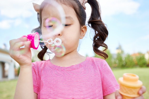 Premium Photo | Cute asian girl blowing bubbles outdoors