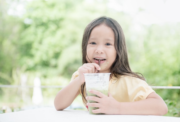 Premium Photo | Cute asian girl drinking ice milk green tea
