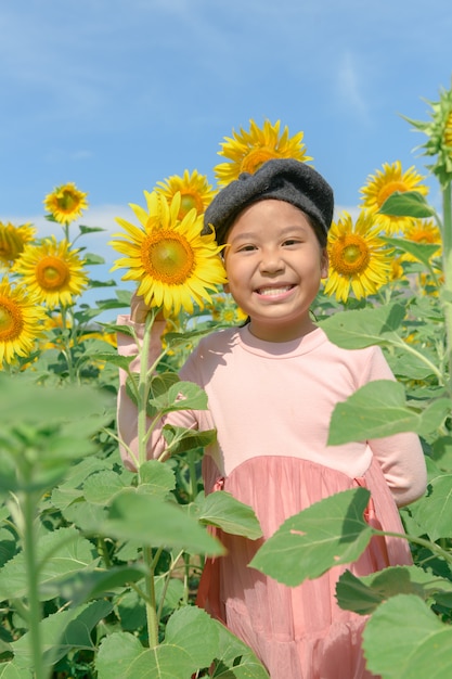 ひまわりの花とかわいいアジアの女の子笑顔 プレミアム写真