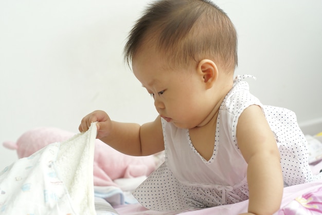 Premium Photo | Cute asian infant baby finding something hidden under a ...