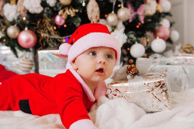 Date Of Old Christmas 2022 Premium Photo | A Cute Baby 6 Months Old In A Santa Costume Lies On A  Blanket Near The Christmas Tree. Christmas 2022