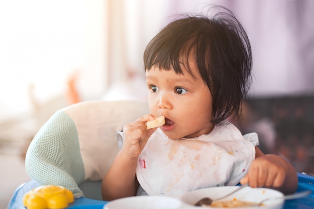 かわいい赤ちゃんアジアの子供の女の子 自分自身で健康的な食べ物 プレミアム写真