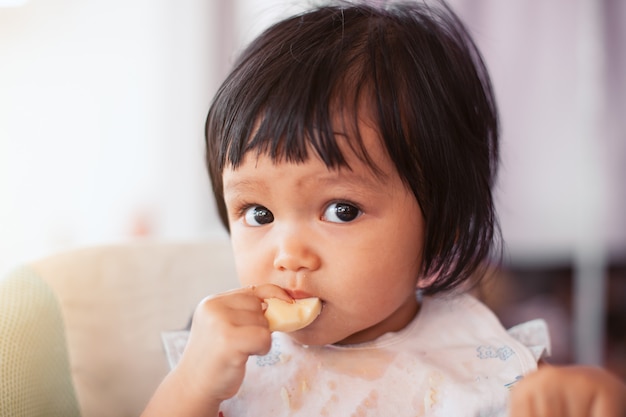 かわいい赤ちゃんアジアの子供の女の子 自分自身で健康的な食べ物 プレミアム写真