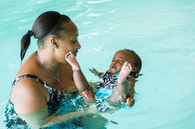 Premium Photo | Cute baby girl learning how to swim in indoor pool.