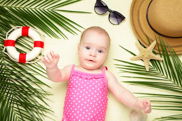 ビーチアクセサリーでかわいい女の子 赤ちゃん 夏のコンセプトと海での休日 プレミアム写真