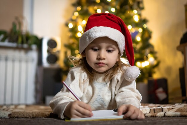 Premium Photo | Cute baby girl write a letter to santa