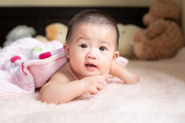 Premium Photo | Cute baby shaking feet while lying in bed