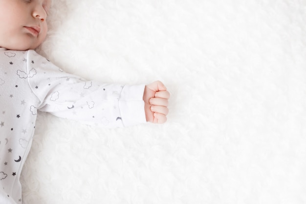 かわいい赤ちゃんはパジャマ姿で寝ています 赤ちゃんの手 プレミアム写真