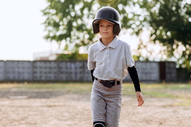 ヘルメットをかぶったかわいい美少女 野球ユニフォームが野球をする プレミアム写真