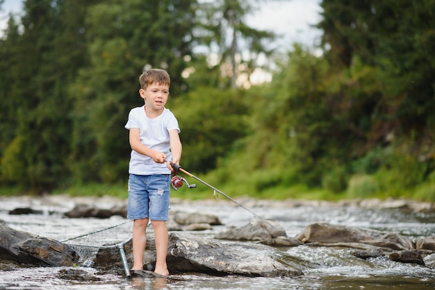 Premium Photo | Cute boy fishing in the river