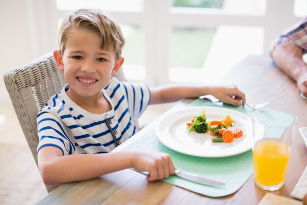 Premium Photo | Cute boy having meal on dinning table