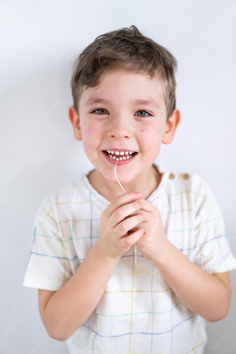 Premium Photo Cute Boy Pulling Loose Tooth Using A Dental Floss