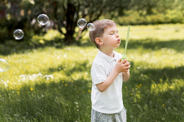 Cute Child Blowing Bubbles With His Toy Free Photo