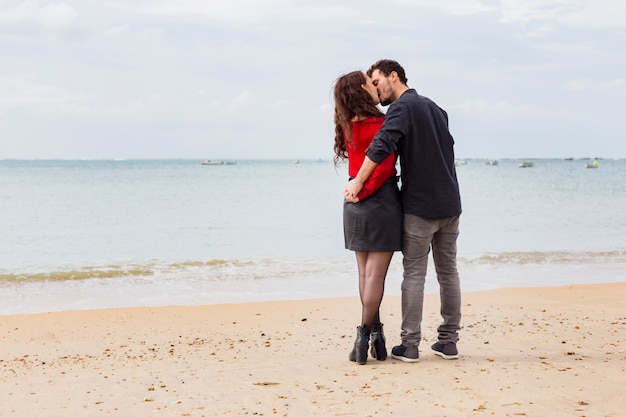 海の海岸でキスしているかわいいカップル 無料の写真