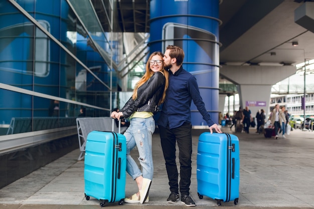 Free Photo | Cute couple with suitcases is standing outside in airport ...