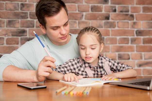 premium-photo-cute-curious-daughter-with-braided-hair-sitting-on-fathers-knees-at-table-and