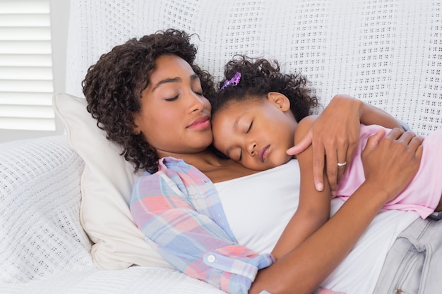 Premium Photo | Cute daughter sleeping with mother on the sofa