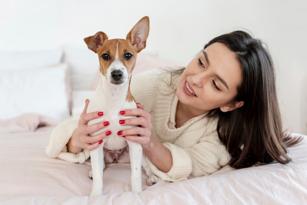 女性に抱かれながらポーズをとるかわいい犬 無料の写真